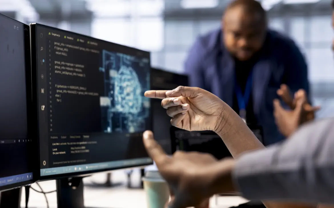 nahaufnahme-eines-datenzentrumsarbeiter-der-mit-dem-finger-auf-ki-technologie-auf-dem-pc-bildschirm-zeigt